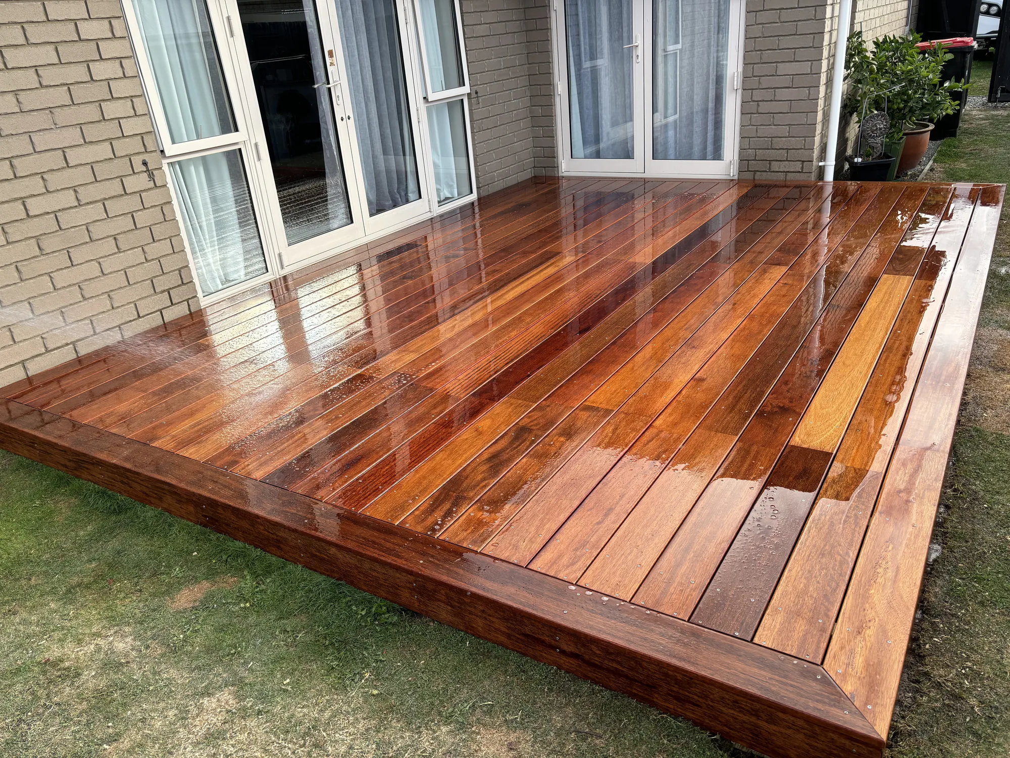 Glossy hardwood deck against a brick home in Christchurch