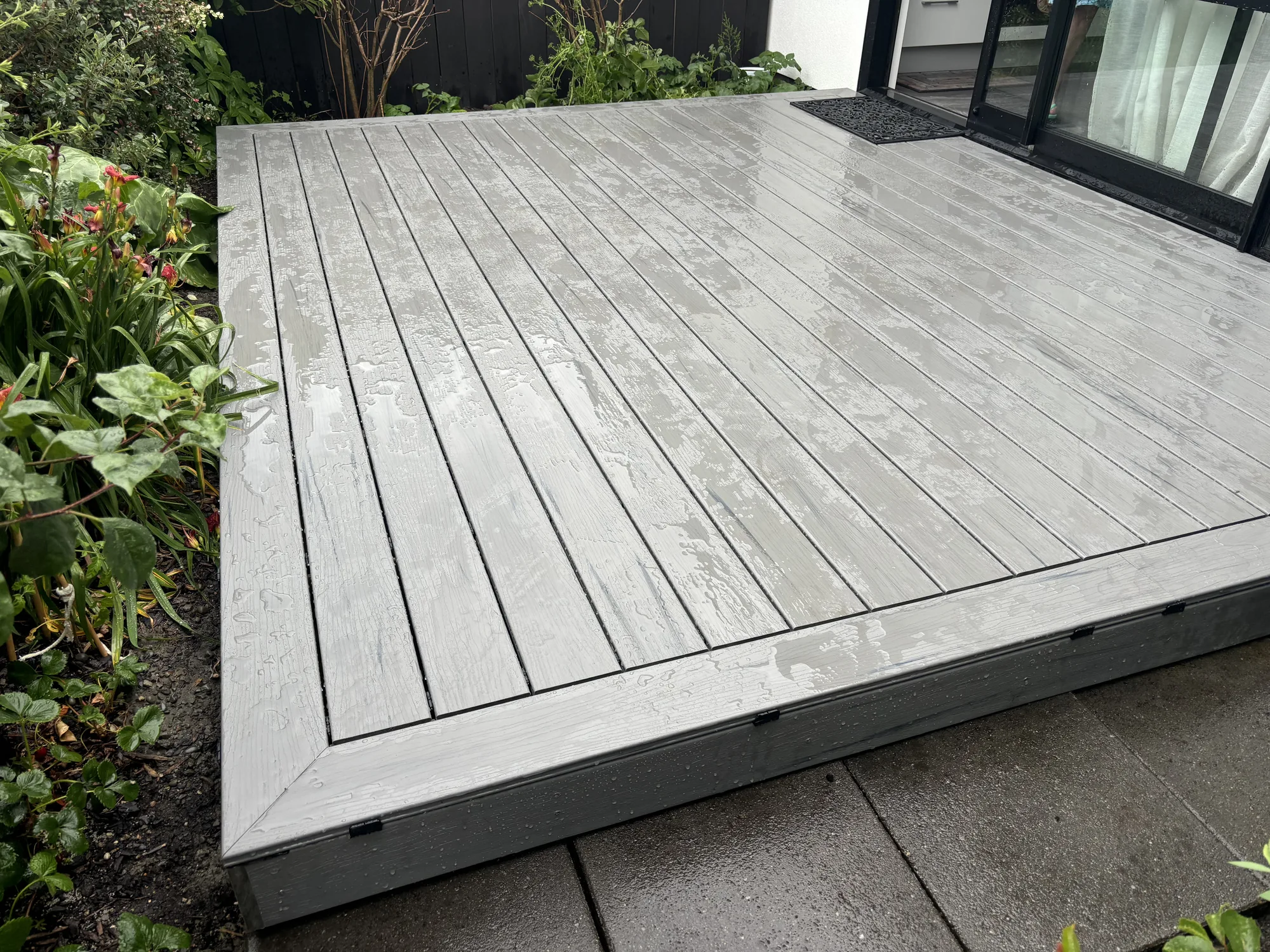 Grey composite deck built alongside a garden in Christchurch